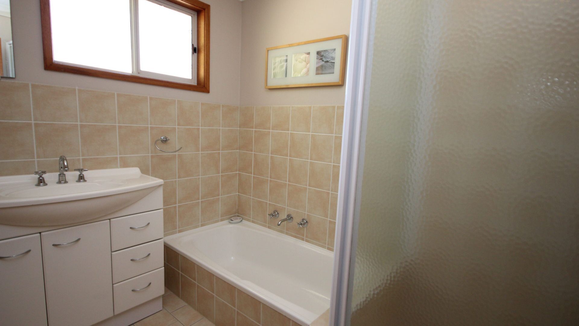 A bathroom with a sink, vanity, and bathtub.