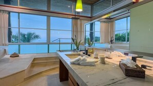 Um banheiro moderno com uma janela ampla, bancada de mármore e vista para o exterior.