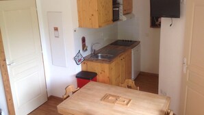 Una cocina compacta con armarios de madera, un lavamanos y una pequeña encimera.
