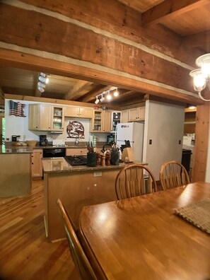 Una cocina acogedora con armarios de madera, una mesa de comedor y una isla de cocina.