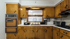 A kitchen with wooden cabinets, a built-in oven, a microwave, and a gas stove.