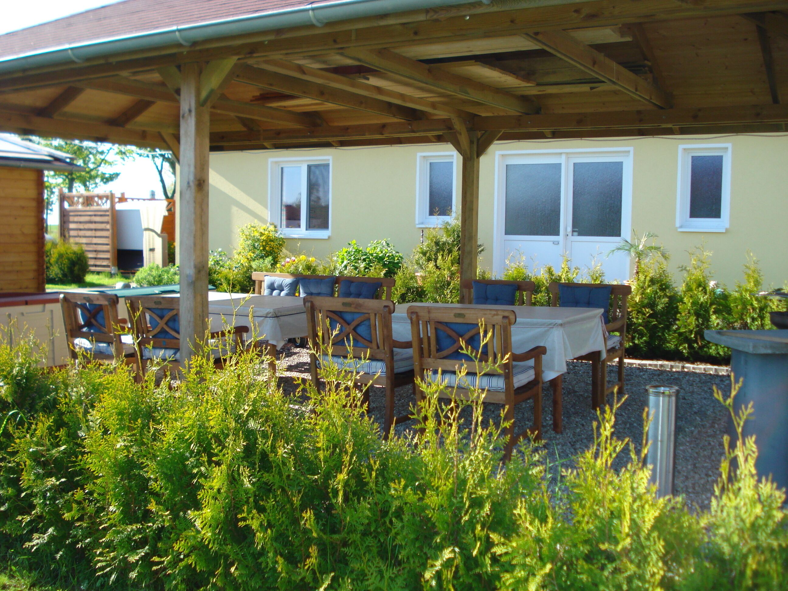 An outdoor patio with wooden furniture and a covered area.