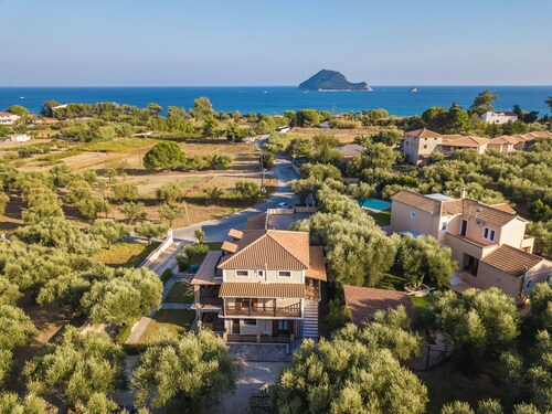 Maisonette-Wohnung mit sichtbaren Balken und einer Terrasse mit Blick auf die Bucht.