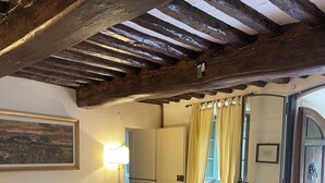 A cozy room with a sofa, a glass coffee table, a patterned rug, and a wooden ceiling. - Authentic Tuscan Villa with Pool and Panoramic Views near Vinci – Tuscany (lamporecchio)