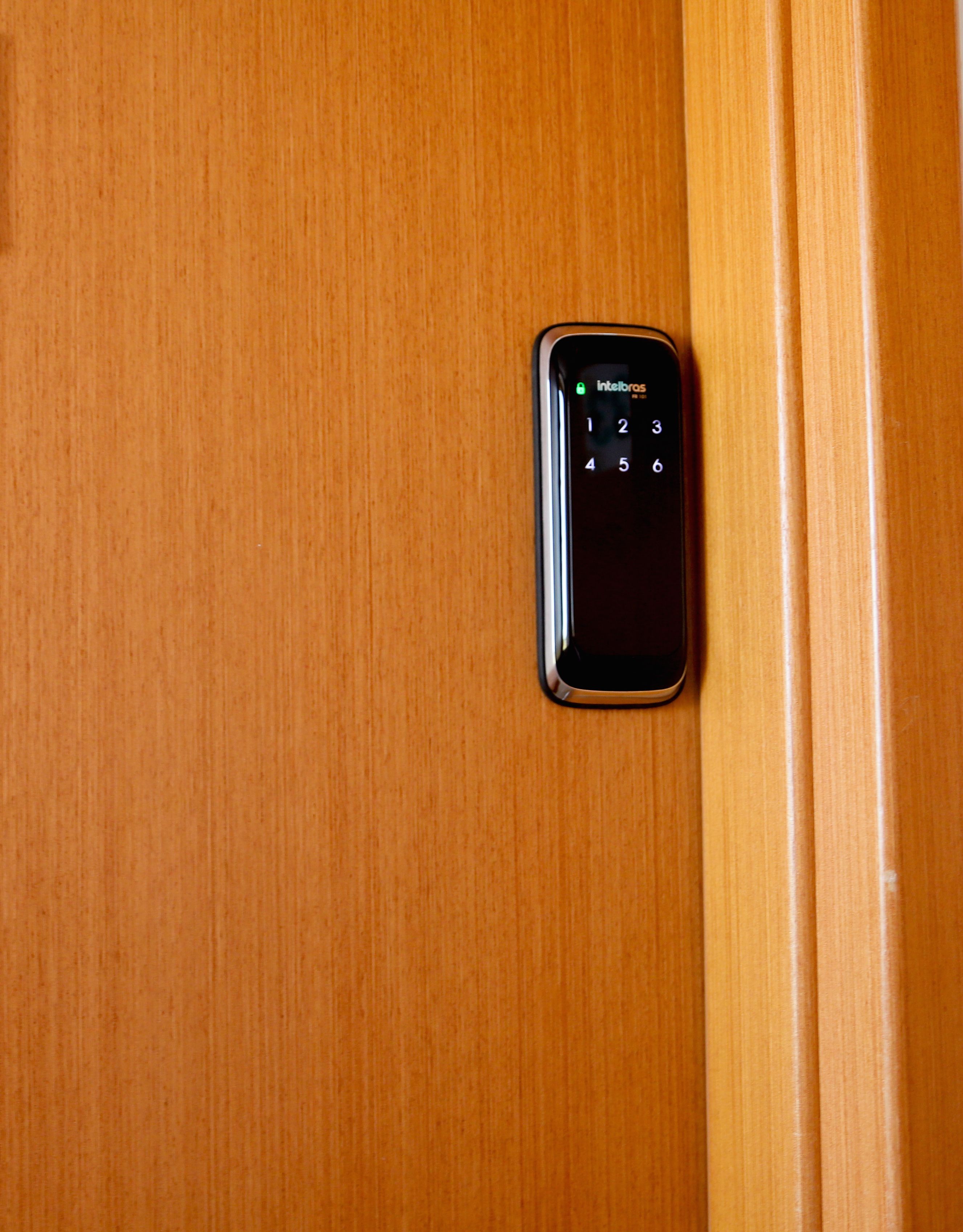 Un clavier numérique sur une porte en bois, probablement utilisé pour accéder à la pièce.