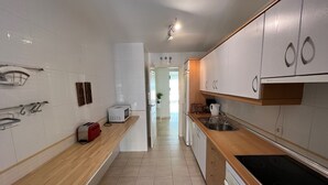 A modern kitchen with white cabinets, a wooden countertop, a built-in oven, and a sink. - Fantastic penthouse of 140m2 (Torrox)