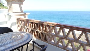 A patio with a mosaic table, wicker chairs, and a wooden railing overlooking the sea. - Fantastic penthouse of 140m2 (Torrox)
