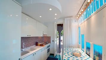 Enjoy meals in this cozy kitchen with a dining area for two, featuring a table and a view of the outdoor space.