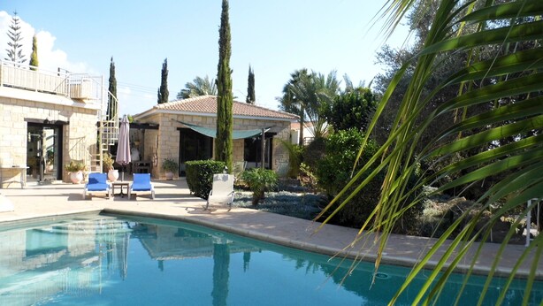A swimming pool with lounge chairs, a stone building, and palm trees. - Villa Manzanillo w/ Private Pool, Sea Views, Double Badminton Court (pickleball) (Peyia)