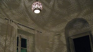 A room with a textured ceiling, a hanging light fixture, and a window with curtains. - Elegant Apartment in Vejer Old Town, renovated but with lovely original features (Vejer de la Frontera)