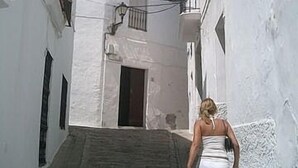 A narrow alleyway with white buildings, a staircase, and a person walking away. - Elegant Apartment in Vejer Old Town, renovated but with lovely original features (Vejer de la Frontera)