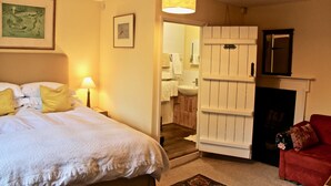 Une chambre à coucher avec un lit, une lampe de chevet et un fauteuil rouge.