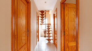 A wooden interior hallway with a staircase.