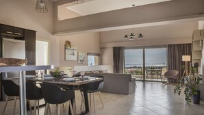 A modern living room with a dining area, large windows with a view, and a balcony. - Sailing Villa Kefalonia (Karavados / Leivathos)