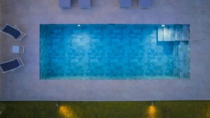 An aerial view of a rectangular swimming pool with a tiled pattern, surrounded by a concrete deck. - Sailing Villa Kefalonia (Karavados / Leivathos)