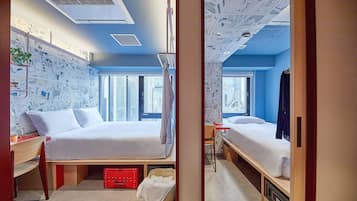 A modern hotel room with a large bed, a desk, and a view of the city.