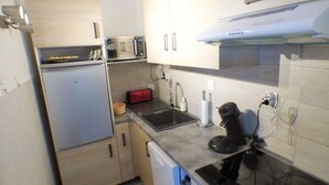 A compact kitchen with a refrigerator, microwave, toaster, sink, and stove. - Facing the sea, sandy beach, everything nearby (LA SEYNE SUR MER)
