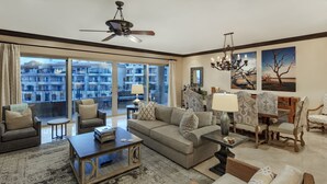 A spacious living room with a large sofa, armchairs, a coffee table, and a dining area with chairs and a table. There is a balcony with a view of the cityscape. - Dream Penthouse - Infinity Jacuzzi + Best View in Cabo (Cabo San Lucas)