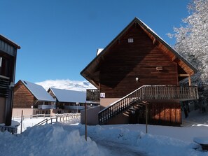 Eine Holzhütte mit einem Balkon und einer Treppe, die zu dem oberen Stockwerk führt.