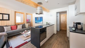 A modern kitchen with a central island, wooden flooring, and a built-in oven. - Chalet Belmont 7 - top location (Wengen)