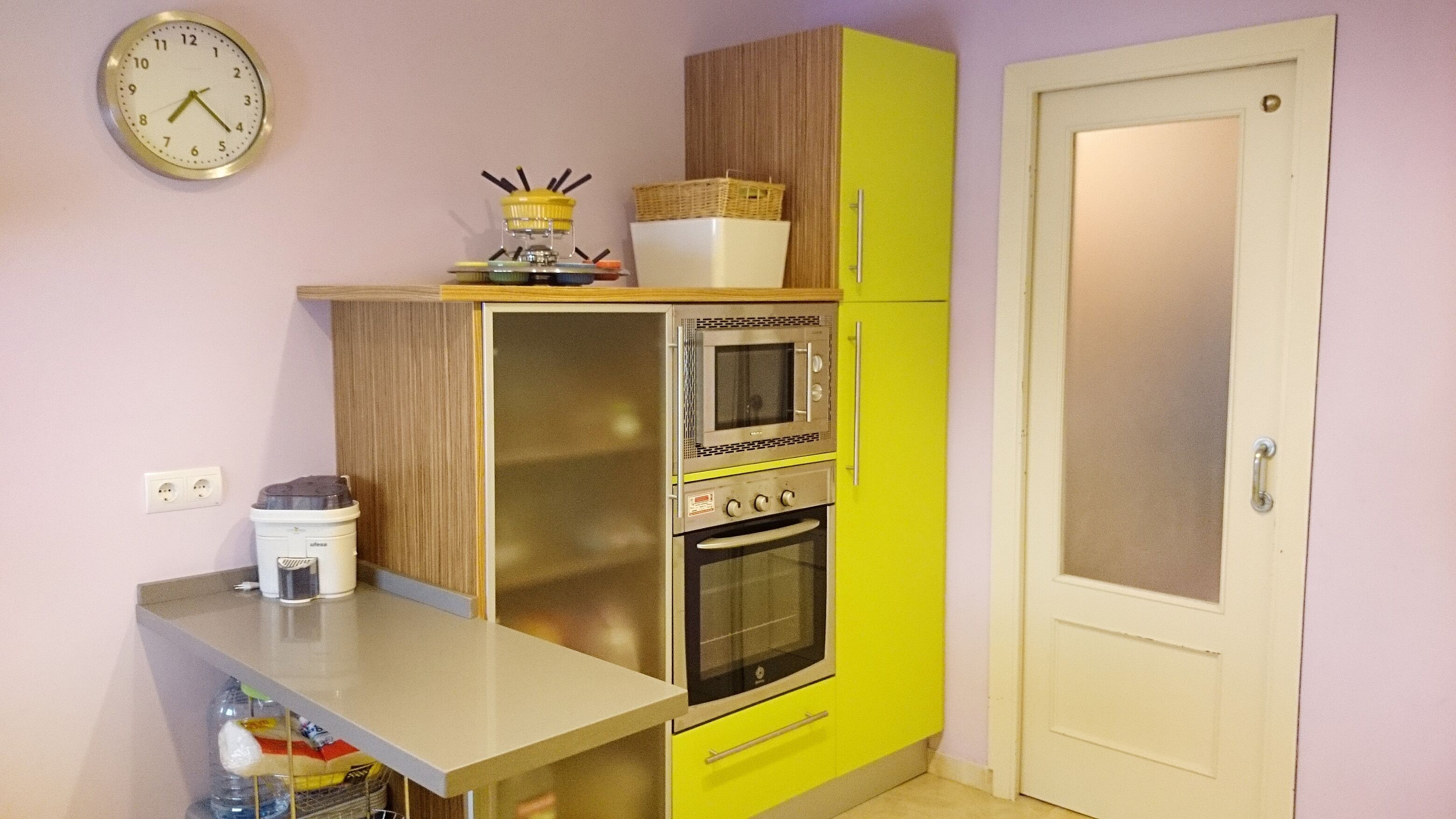 Une cuisine compacte équipée d’un four à micro-ondes, d’un four traditionnel et d’un petit plan de travail.