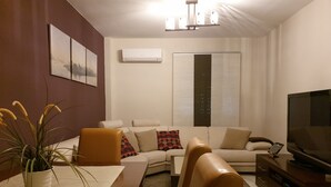 Ein modernes Wohnzimmer mit einer Couch, einem Couchtisch und einer TV-Konsole.
