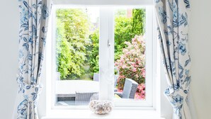 A window with white curtains featuring a blue floral pattern. - Delightful house in Stone, Staffordshire  close to lovely canal side walks.   (Stone)