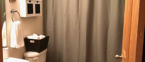 A bathroom with a toilet, sink, and a shower curtain.