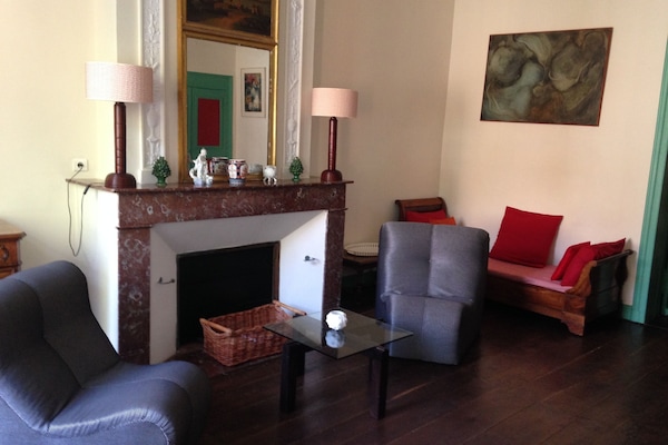 coin salon avec cheminée en marbre des Pyrénées et lit d'appoint Restauration