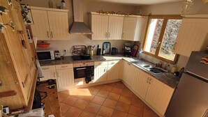 A kitchen with white cabinets, a stainless steel refrigerator, and a window providing natural light. - Cosy Chalet in the Real Alps near Annecy.
Relax, chill, walk, cycle, trek, ski. (Le Châtelard)
