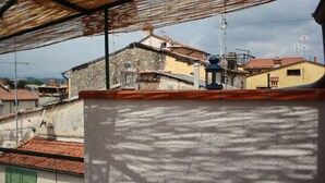 Vista di un edificio con tetto in tegole e struttura con tetto di paglia.