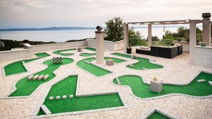 A miniature golf course with a scenic view of the sea and mountains in the background. - Holidayhome in a quiet location with pool&sea view, mini golf course& playground (Makarska)