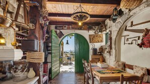 A rustic kitchen with wooden beams, a green archway, and various kitchen utensils. - Holidayhome in a quiet location with pool&sea view, mini golf course& playground (Makarska)