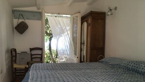 Una camera da letto con un letto, una sedia, un tavolo e un armadio.