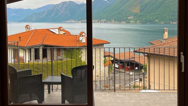 Ein Balkon mit Blick auf einen See und Berge.