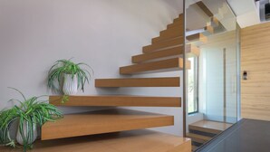 Una escala moderna amb graons de fusta i barana de vidre.