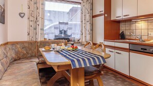 A cozy dining area with a wooden table, chairs, and a view of the outside. - Pleasant and bright: The ground floor apartment with its ca. (Carolinensiel)