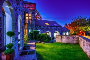 A stone building with arched windows and a well-maintained lawn. - Amazing Family House Sleeps 12 with  Private Hot Tub in Tranquil Location (Holmfirth)