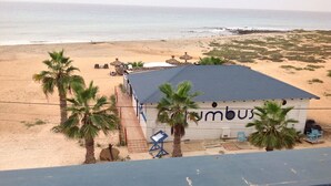 Un edificio sulla spiaggia con un cartello che riporta la scritta "umbus".