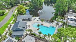 Zona residencial con piscina, fuente y vistas a un lago.