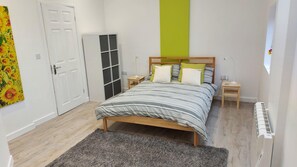 A bedroom with a bed, bedside tables, a wardrobe, a radiator, and a door. - A Quirky, Modern Converted Barn, Quiet Rural Setting With Easy Access To Kendal (Kendal)