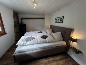 Une chambre à coucher avec un lit, une table de chevet, une lampe et un tableau encadré au mur.