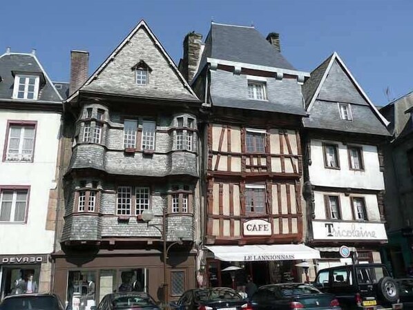A row of traditional European-style buildings with a cafe and a restaurant. - Bright apartment Sea view - Pink Granite coast - PROMO September-October (Pleumeur-Bodou)