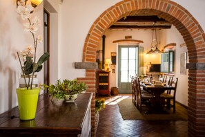 Enjoy meals in this charming dining area with a rustic brick archway leading to the kitchen.