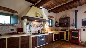 Une cuisine avec des meubles de rangement en bois, une cuisinière et un four rouge.