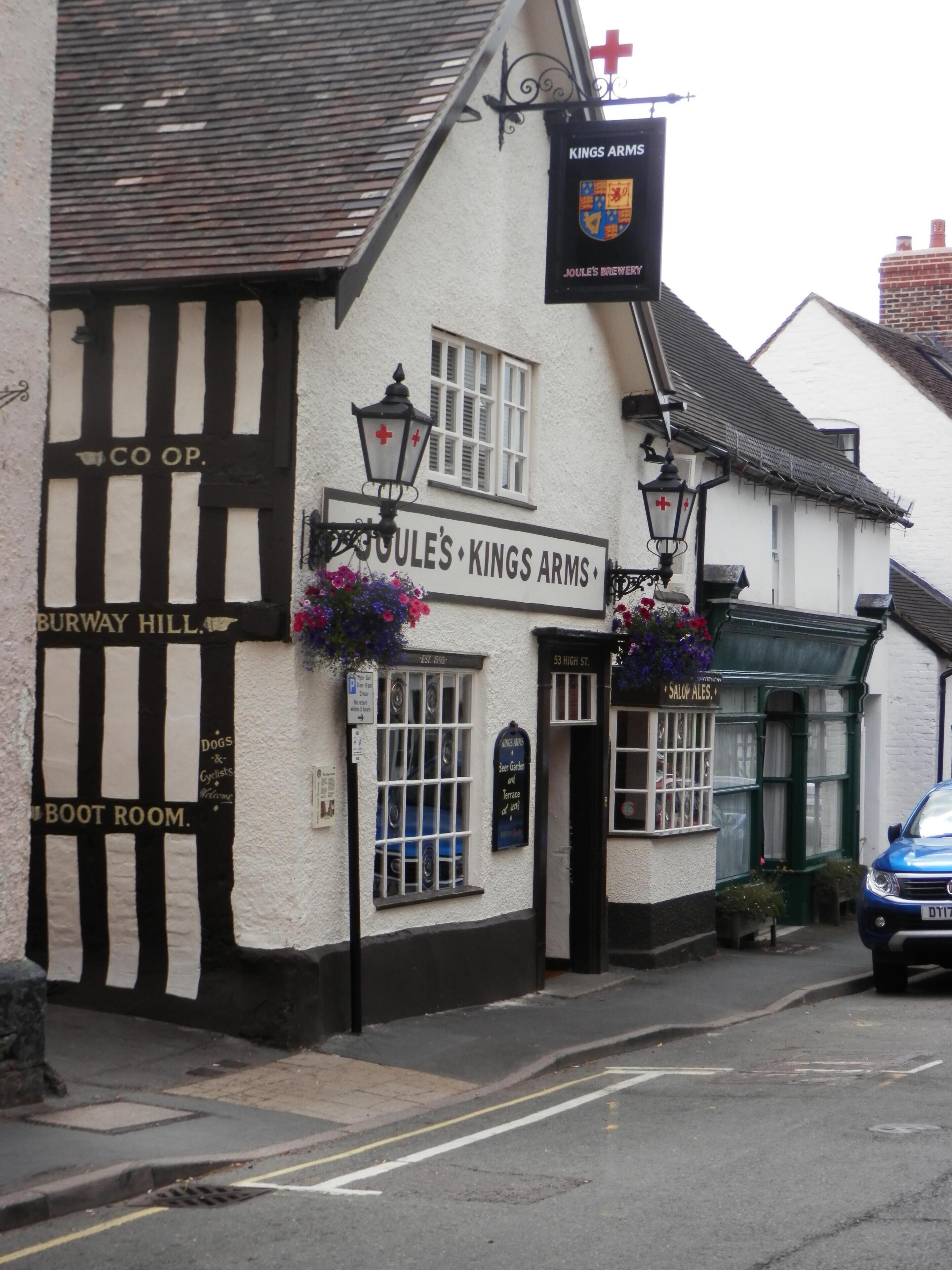A traditional pub named 'Kings Arms' with a signboard, a boot room, and a beer garden.