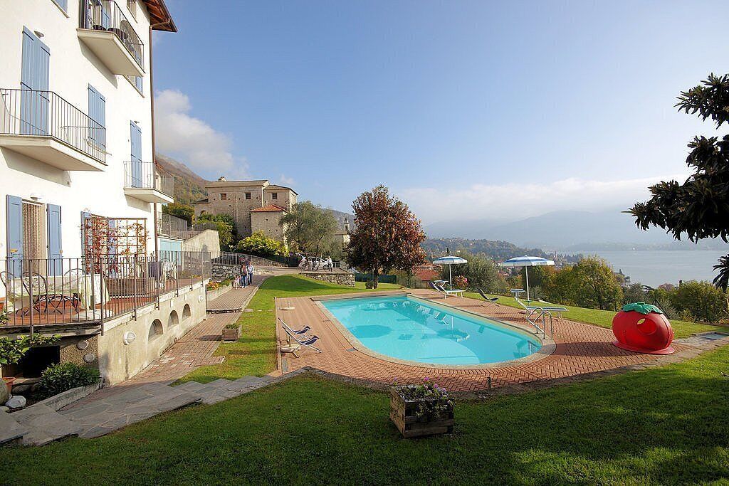 Ein Pool mit Meerblick, eine Rasenfläche und ein Gebäude mit Balkonen.