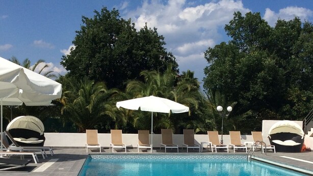 A rectangular pool with clear blue water, surrounded by lounge chairs and umbrellas. - Alizé T3 for 6 people (San-Nicolao)
