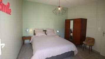 Un dormitorio con cama, lámparas de noche, armario y una silla.