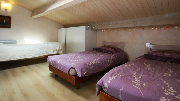 A bedroom with two beds, a wardrobe, and a skylight.